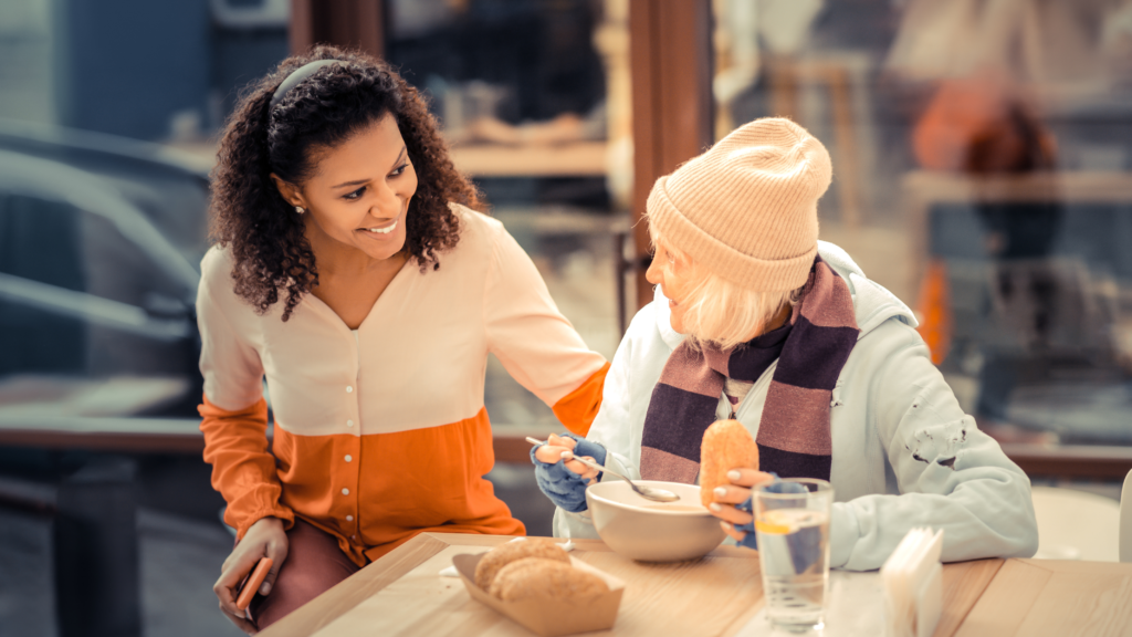 Two women sit at a table and talk
